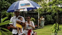 Terlihat keluarga kecil ini tampak semringah mengikuti rangkaian ibadah di tengah hujan.