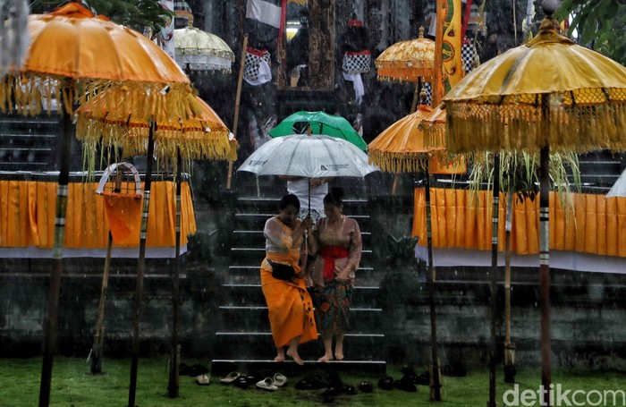 Semangat Umat Hindu Beribadah di Tengah Hujan Deras Perayaan Hari Raya Kuningan di Pura Dalem Purnajati, Jakarta Utara, diguyur hujan deras, Sabtu (29/2). Walaupun begitu mereka tetap semangat beribadah.