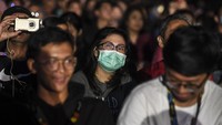 Seorang penonton terlihat memakai masker.