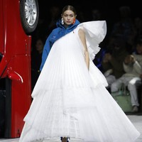  Gigi Hadid memberikan penampilan penuh drama dengan gaun putih A-line yang megar dari label favorit kaum hypebeast itu. Gaun tersebut dipadukan dengan cropped jacket asimetris biru. Foto: Getty Images/Thierry Chesnot