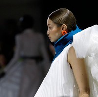 Gayanya kian dramatis dengan tumpukan ruffle di bagian belakang gaun. Gayanya kian sempurna dengan statement necklace dan heels biru bergaya futuristik.  Foto: Getty Images/Thierry Chesnot