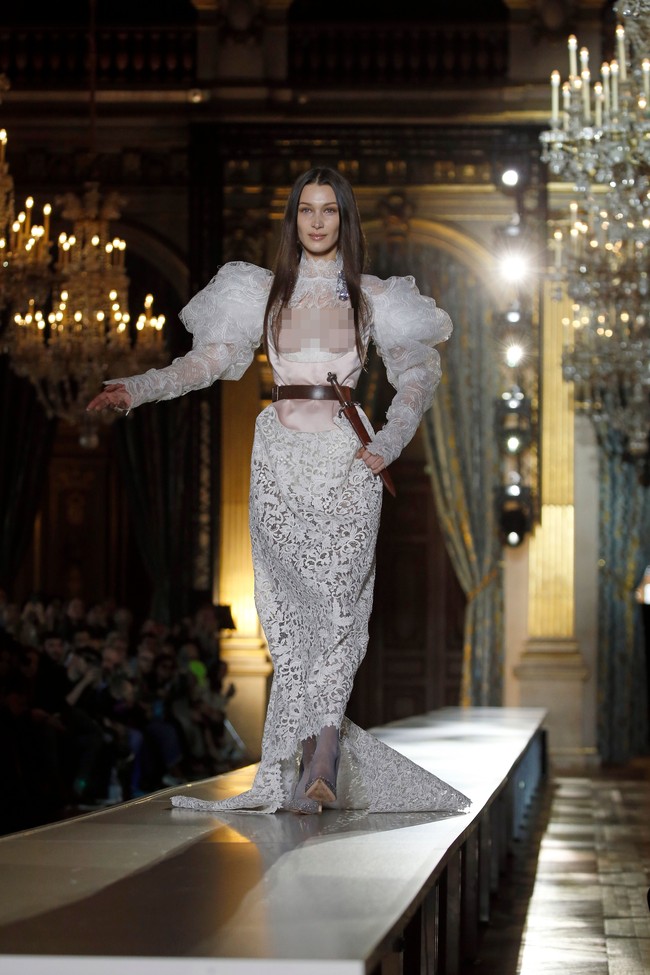 Model 23 tahun itu menggunakan gaun putih berbahan laser cut. Bagian lengannya dibuat bervolume.  Foto: Getty Images/Thierry Chesnot