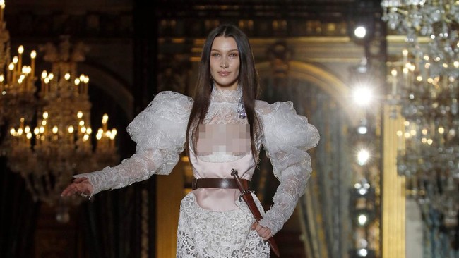 Dalam penampilannya, Bella tampil sensual dengan sengaja tidak menggunakan bra sehingga bagian dada terekspos.  Foto: Getty Images/Thierry Chesnot