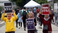 Sejumlah mahasiswa tampak melintasi zebra cross sembari membawa poster yang berisi dukungan untuk KPAI.