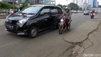 Sejumlah kendaraan melintasi jalan yang berlubang di kawasan MT Haryono, Jakarta.