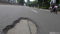 Seorang pengendara motor melintasi Jalan Gatot Subroto arah Cawang yang berlubang, Jakarta, Minggu (1/3/2020).