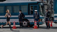 Seorang pelari yang ikut serta dalam Maraton Tokyo 2020 melintas di samping sejumlah petugas kepolisian yang bertugas di area sekitar kegiatan olahraga internasional tersebut.