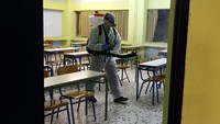 Seorang petugas menyemprotkan desinfektan di ruang kelas salah satu sekolah yang berada di Kota Athena, Yunani, Sabtu (29/2) waktu setempat. AP Photo/Yorgos Karahalis.