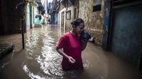 Seorang warga berjalan melintasi banjir di kawasan Kebon Pala, Jatinegara, Senin (2/3/2020).