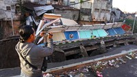 Seorang jurnalis mengambil gambar pertokoan Jompo yang ambruk di Jalan Sultan Agung Jember, Jawa Timur, Senin (2/3/2020).