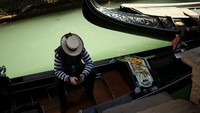 Siapa pun jatuh cinta dengan Venesia. Biasanya para turis bersesakan untuk naik gondola, kini wisata sepi. (Francisco Seco/AP)