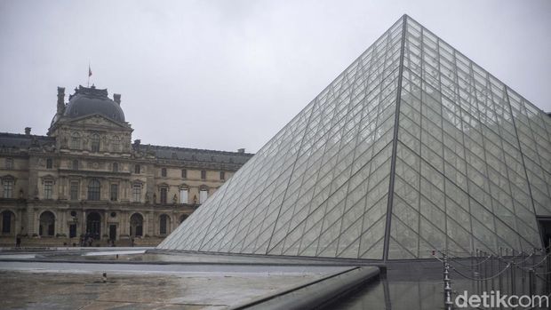 People walk by the Louvre museum, in Paris, France, Sunday, March 1, 2020. The spreading coronavirus epidemic shut down France's Louvre Museum on Sunday, with workers who guard its trove of artworks fearful of being contaminated by the museum's flow of visitors from around the world. (AP Photo/Rafael Yaghobzadeh)