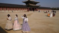 Korea Selatan juga menjadi negara yang terdampak virus Corona. Meski demikian, masih ada turis yang datang ke Gyeongbokung Palace dengan menggunakan masker. (ED JONES/AFP via Getty Images)