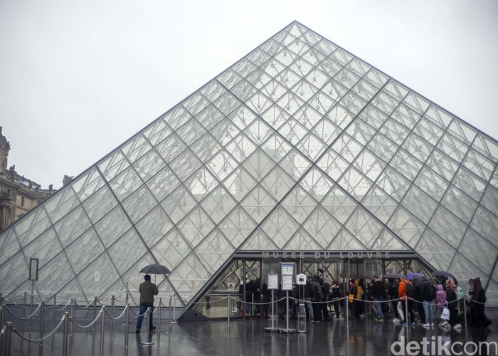 People walk by the Louvre museum, in Paris, France, Sunday, March 1, 2020. The spreading coronavirus epidemic shut down Frances Louvre Museum on Sunday, with workers who guard its trove of artworks fearful of being contaminated by the museums flow of visitors from around the world. (AP Photo/Rafael Yaghobzadeh)