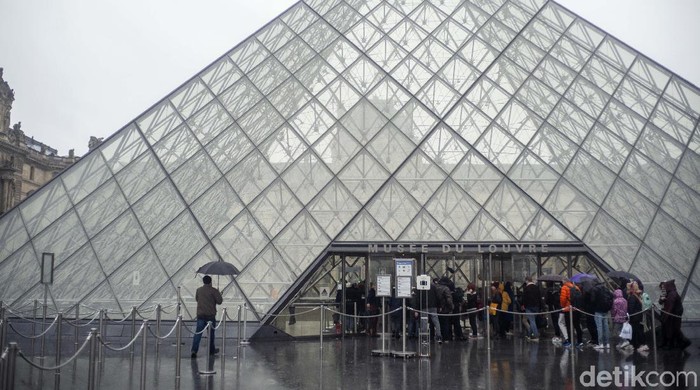 People walk by the Louvre museum, in Paris, France, Sunday, March 1, 2020. The spreading coronavirus epidemic shut down Frances Louvre Museum on Sunday, with workers who guard its trove of artworks fearful of being contaminated by the museums flow of visitors from around the world. (AP Photo/Rafael Yaghobzadeh)