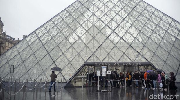 People walk by the Louvre museum, in Paris, France, Sunday, March 1, 2020. The spreading coronavirus epidemic shut down France's Louvre Museum on Sunday, with workers who guard its trove of artworks fearful of being contaminated by the museum's flow of visitors from around the world. (AP Photo/Rafael Yaghobzadeh)