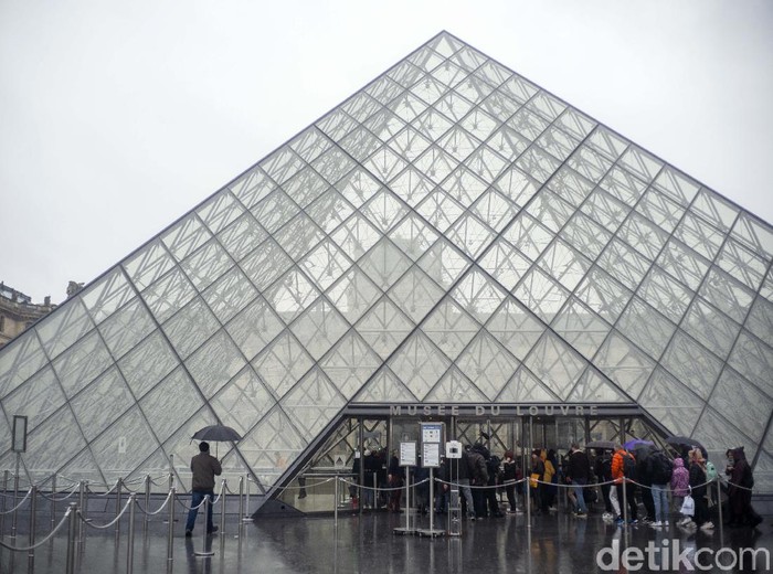 People walk by the Louvre museum, in Paris, France, Sunday, March 1, 2020. The spreading coronavirus epidemic shut down Frances Louvre Museum on Sunday, with workers who guard its trove of artworks fearful of being contaminated by the museums flow of visitors from around the world. (AP Photo/Rafael Yaghobzadeh)
