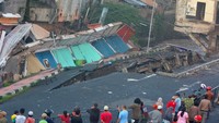 Tanah di atas bangunan ruko ini amblas ke sungai yang berada di sisi selatan jalan.