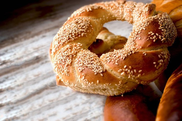 Freshly baked homemade crispy pretzel with sesame on rustic table