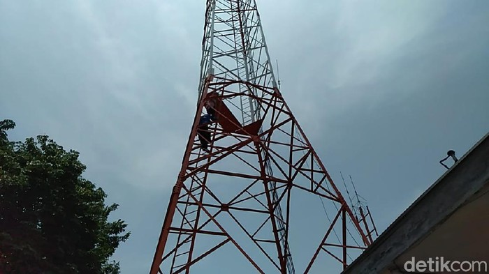 Seorang pedagang di Taman Pancasila kompleks Stasiun Kota Tegal nekat panjat tower setelah kiosnya dieksekusi Pemkot Tegal, Selasa (3/3/2020).