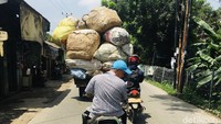 Seorang pengendara sepeda motor membawa penumpang dua ekor kambing dengan tas bawaan disisi kanan dan kirinya. Sepanjang jalan kambing terus mengembek dan sontak menjadi pusat perhatian orang.