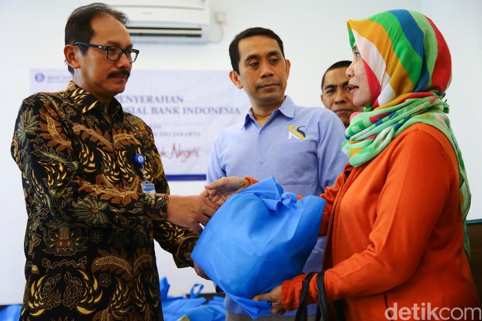 Petugas tengah membagikan paket bantuan untuk perwakilan korban banjir DKI Jakarta, Selasa (3/3/2020). Sebanyak 200 paket yang berisikan kebutuhan sehari-hari ini dibagikan kepada 13 perwakilan korban banjir di Jakarta Barat dan Jakarta Utara. Kepala Bank Indonesia Perwakilan DKI Jakarta Hamid Ponco Wibowo (kiri) didampingi  Anggota Komisi XI DPR RI Fraksi Gerindra Kamrussamad (kanan) memberikan bantuan tersebut kepada perwakilan korban banjir.