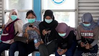 Sejumlah warga tampak mengenakan masker saat sedang menunggu bus di halte TransJakarta Harmoni, Jakarta, Selasa (3/3/2020).