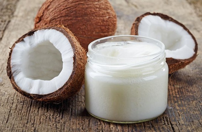 coconut oil and fresh coconuts on old wooden table