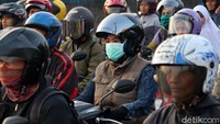Sebagian pengandara motor menggunakan masker dan ada juga pengendara yang tidak menggunakan masker.