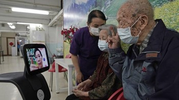 Dua orang lansia tengah berkomunikasi dengan kerabat mereka melalui robot Temi di pusat perawatan lansia yang berada di kawasan Hong Kong.