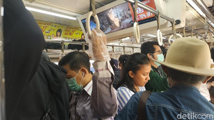 Penumpang KRL Commuter Line Penumpang KRL Commuter Line menggunakan sarung tangan plastik untuk cegah virus corona.