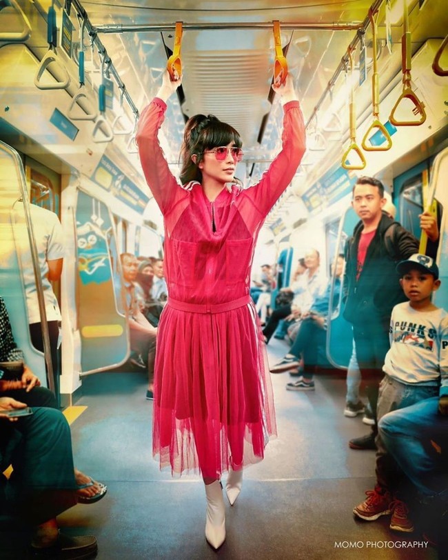 Ussy Pratama memilih tampilan serba pink. Mulai dari atasan dan bawahan rok yang berwarna senada, hingga kacamata. Ussy memadukan tampilannya tersebut dengan sepatu ankle boots berwarna putih. Foto: Instagram