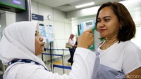 Satu per satu calon penumpang yang hendak menggunakan MRT diperiksa suhu tubuhnya oleh para petugas kesehatan.