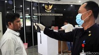 Petugas melakukan pemeriksaan suhu tubuh bagi para pengunjung yang hilir mudik memasuki Gedung Mahkamah Konstitusi, Jakarta, Rabu (4/3/2020).