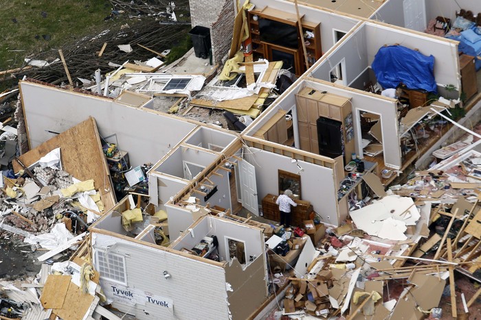 People walk past buildings damaged by storms Tuesday, March 3, 2020, in Nashville, Tenn. Tornadoes ripped across Tennessee early Tuesday, shredding buildings and killing multiple people.  (AP Photo/Mark Humphrey)