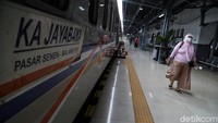 Seorang warga tampak melintas di samping kereta yang bersiap untuk berangkat di Stasiun Pasar Senen, Jakarta.