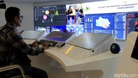 Sekilas, ruangan ini mirip dengan pusat komando di film-film fiksi seperti Star Trek atau Star Wars. Di sana, informasi seputar Covid-19 ditampilkan melalui layar raksasa yang membentang di sepanjang bagian depan ruangan.