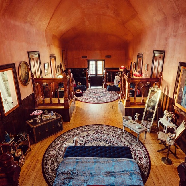 Bagian dalam dari bangunan unik ini masih memiliki desain unik abad ke 20 dengan beberapa sentuhan tambahan seperti troli minuman, set catur, dan ember sampanye kecil serta tempat tidur kanopi bertirai merah dan bathub. Foto: Instagram Lucy The Elephant