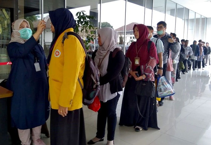 Karyawan Pertamina Diperiksa Suhu Tubuh Para pekerja dan tamu yang berada di Kantor Pusat Pertamina turut menjalani pemeriksaan kesehatan. Tamu dan karyawan Pertamina tampak antre untuk diperiksa suhu tubuhnya.