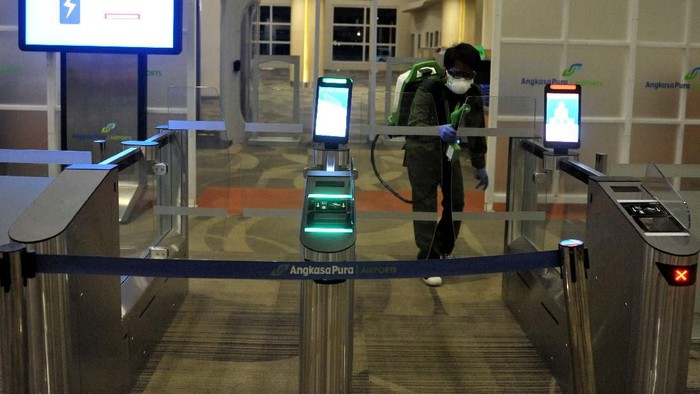 Awak kabin berjalan di dekat alat penyemprot cairan disinfektan otomatis yang dipasang petugas Kantor Kesehatan Pelabuhan (KKP) Kelas I Denpasar di kawasan Terminal Domestik Bandara Internasional I Gusti Ngurah Rai, Bali, Selasa (3/3/2020). Kegiatan desinfeksi yang dilakukan di area terminal domestik dan internasional bandara tersebut dilakukan sebagai salah satu langkah antisipasi potensi penyebaran COVID-19 atau virus Corona. ANTARA FOTO/Fikri Yusuf/aww.