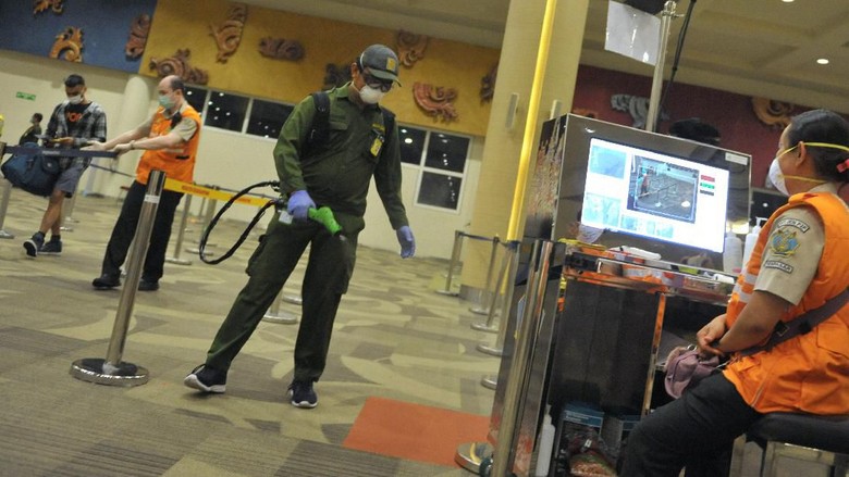 DESINFEKSI DI BANDARA NGURAH RAI Awak kabin berjalan di dekat alat penyemprot cairan disinfektan otomatis yang dipasang petugas Kantor Kesehatan Pelabuhan (KKP) Kelas I Denpasar di kawasan Terminal Domestik Bandara Internasional I Gusti Ngurah Rai, Bali, Selasa (3/3/2020). Kegiatan desinfeksi yang dilakukan di area terminal domestik dan internasional bandara tersebut dilakukan sebagai salah satu langkah antisipasi potensi penyebaran COVID-19 atau virus Corona. ANTARA FOTO/Fikri Yusuf/aww.