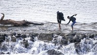 Dua orang migran melintasi Sungai Maritsa dalam perjalanan mereka menuju perbatasan Yunani yang berada di dekat Edirne, Turki, Selasa (3/3/2020) waktu setempat. AP Photo/Darko Bandic.