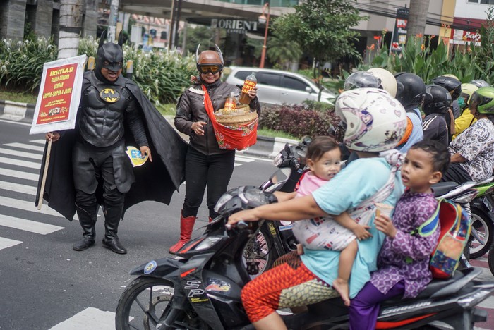 Sejumlah pahlawan super memberikan sosialisasi pengecegahan virus corona di kawasan Solo. Mereka juga turut membagikan jamu gratis kepada para pengguna jalan.