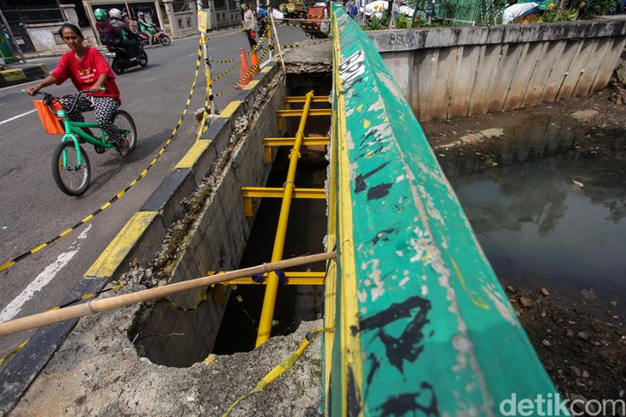 Duh! Trotoar di Jembatan Petojo Bolong Seorang warga melintas di sisi jembatan kawasan Petojo Utara, Jakarta Pusat, Rabu (4/3/2020). Trotoar di jembatan ini terlihat bolong dan tak dapat digunakan.