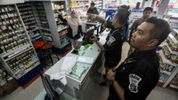 Personel Polisi Satuan Reserse Kriminal memeriksa lemari penyimpanan barang di sebuah apotek, di Lhokseumawe, Aceh, Rabu (4/3/2020). 