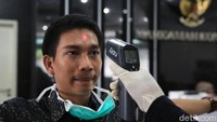 Satu per satu suhu tubuh pengunjung diperiksa oleh para petugas.