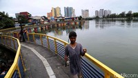 Sejumlah warga kerap datang ke Danau Sunter untuk memancing. Seorang warga tampak membawa alat pancingan di kawasan Danau Sunter Jaya, Jakarta Utara.