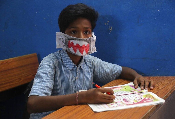 Siswa Sekolah di India Pakai Masker Virus corona membuat warga dunia gunakan masker untuk cegah penyebaran COVID-19. Siswa di India pun tak ketinggalan pakai masker buatan sendiri saat bersekolah.