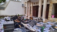 Barang-barang seperti kertas dan peralatan kantor sudah berhamburan di jalan. Sebagian barang bahkan sudah hangus terbakar.