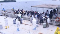 Sejumlah petugas tampak mengenakan pakaian pelindung dan juga masker saat membantu para WNI ABK Diamond Princess yang tiba di Pulau Sebaru Kecil. Antara Foto/Puspen TNI/Pelda Dawid.